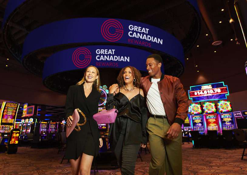 Couple walking with woman friend on casino floor in front of Rewards Kiosk