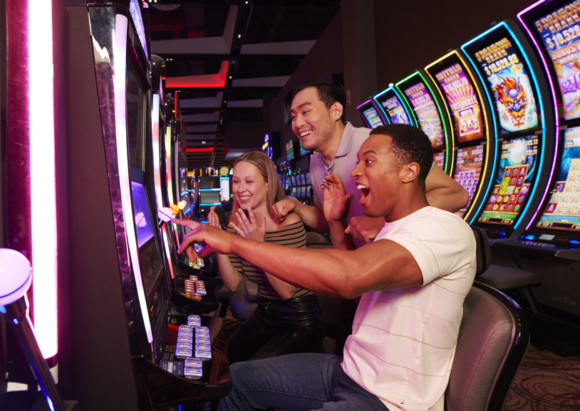 Man sitting a slot machine with friends just won jackpot