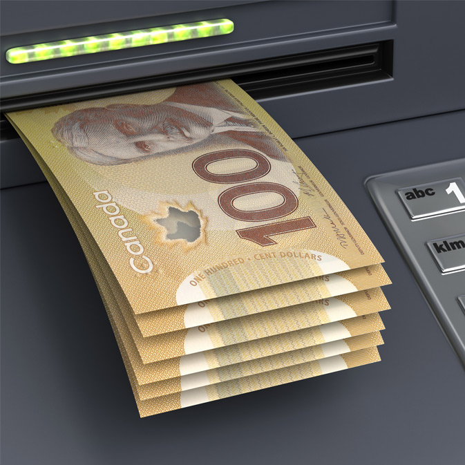 A proud Canadian dollar bill is being inserted into an ATM machine.