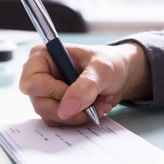 A hand is proudly holding a pen and writing on a piece of paper.