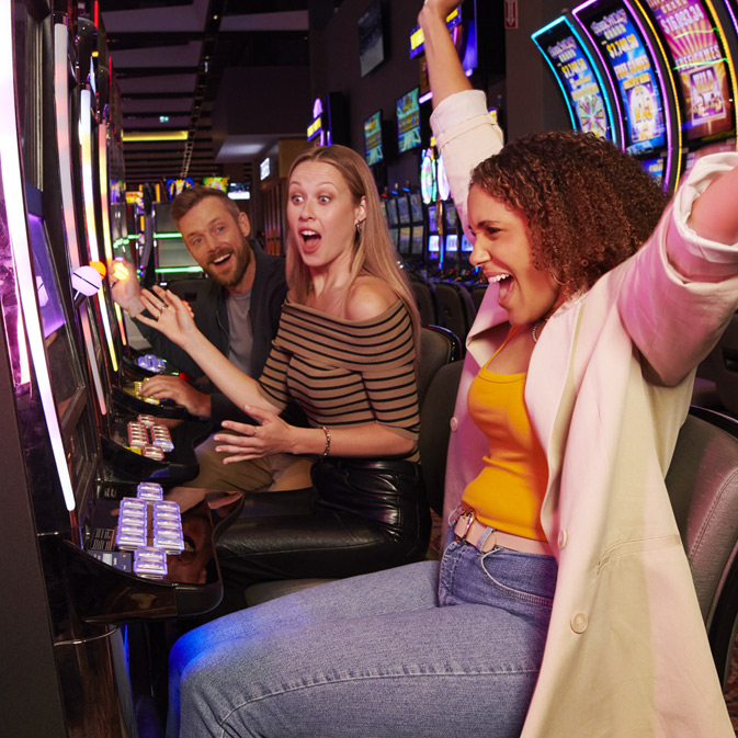 A group of Great Canadian individuals playing slot machines in a casino.