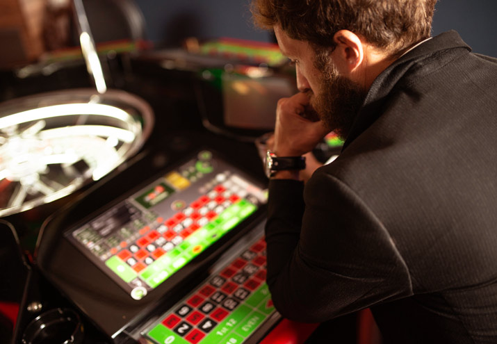 Man at electronic table game concentrating