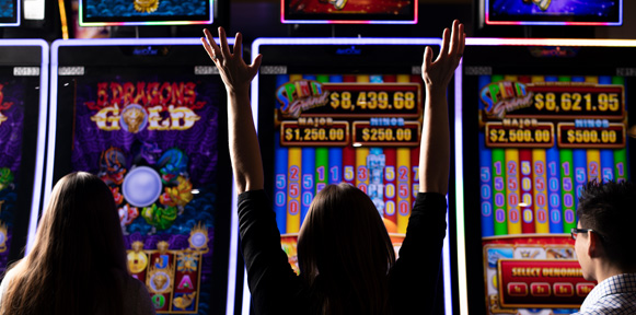 A group of people playing slot machines at Elements Casino.