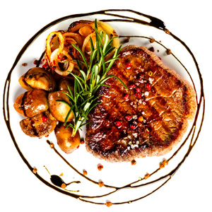 A flavorful steak topped with mushrooms and savory sauce, elegantly presented on a plate.