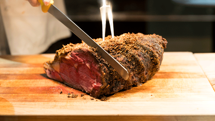 A person using WIFI to cut a piece of meat on a cutting board at the River Rock Casino Resort.