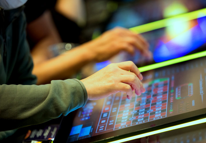 Hands playing electronic table games.
