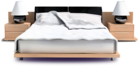 Hotel bed with white blanket, wood frame and side tables with lamps